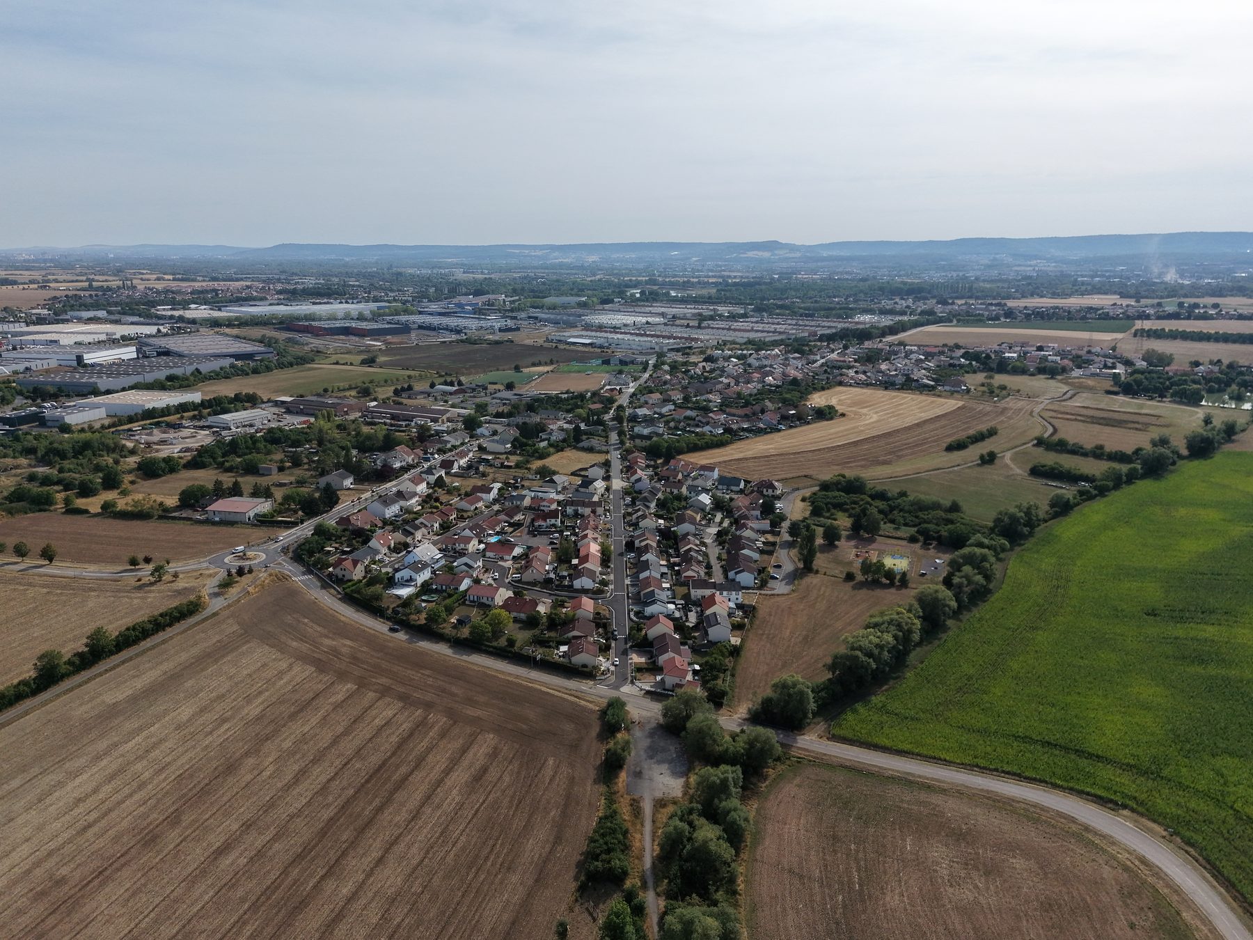 Drone aerial view of a river bend near a small village and farmland