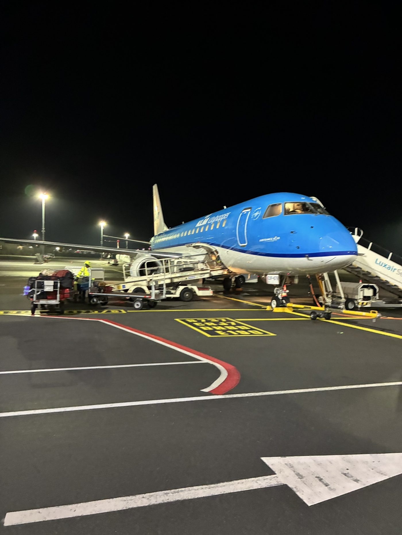 An aircraft parked on the tarmac at night under airport lighting
