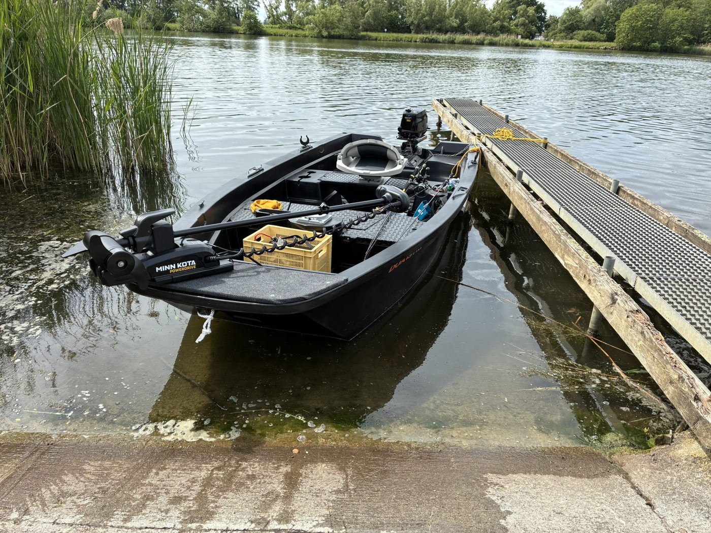 A small fishing boat moored at a quiet riverside dock
